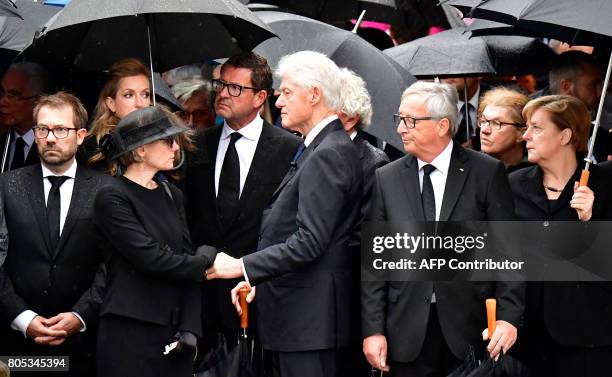 President of the EU Commission Jean-Claude Juncker and German Chancellor Angela Merkel watch as former US President Bill Clinton presents his...