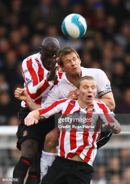 Nyron Nosworthy of Sunderland jumps for a header with Brian McBride of Fulham and team mate Grant Leadbitter of Sunderland during the Barclays...