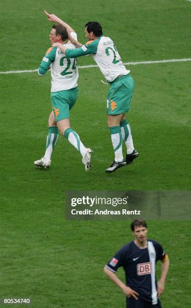 Tim Borowski of Bremen celebrates with his team mate Hugo Almeida after the third goal as Arne Friedrich of Berlin reacts during the Bundesliga match...