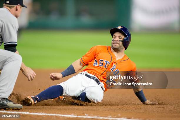 Houston Astros second baseman Jose Altuve slides into third base on Carlos Correa single in the fourth inning during a MLB baseball game between the...