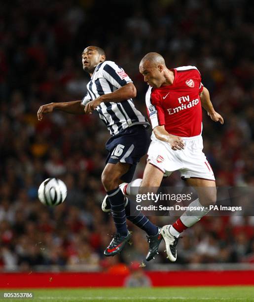 Arsenal's Mikael Silvestre and West Bromwiich Albion's Luke Moore battle for the ball in the air