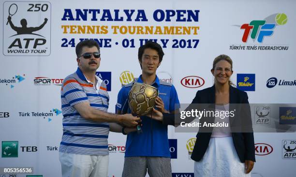 Yuichi Sugita of Japan receives his trophy after defeating Adrian Mannarino of France during their men's final match of ATP World Tour 250 Antalya...