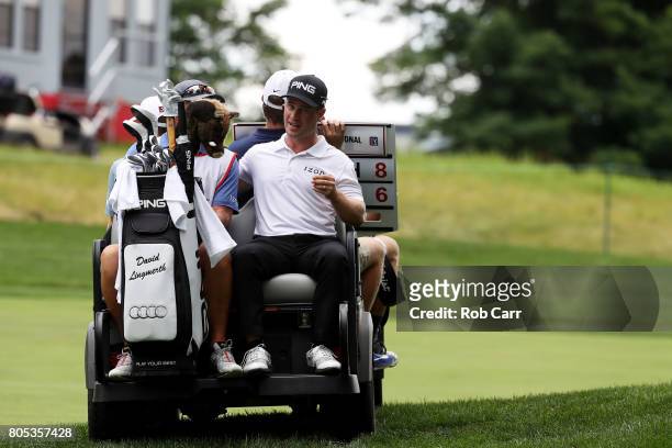 David Lingmerth of Sweden rides in the back of a cart after play was suspended due to weather during the third round of the Quicken Loans National on...