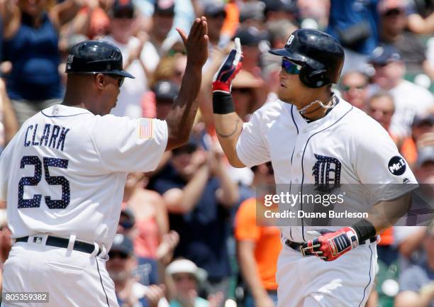 Miguel Cabrera of the Detroit Tigers receives a high-five from third base coach Dave Clark of the Detroit Tigers after hitting a solo home run...