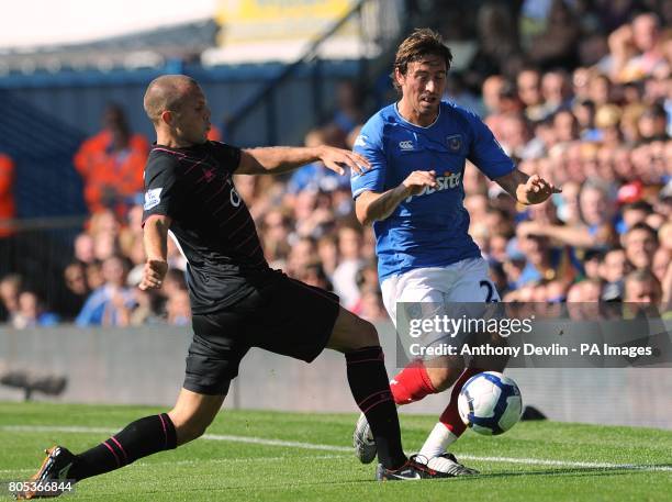 Everton's Johnny Heitinga and Portsmouth's Tommy Smith battle for the ball