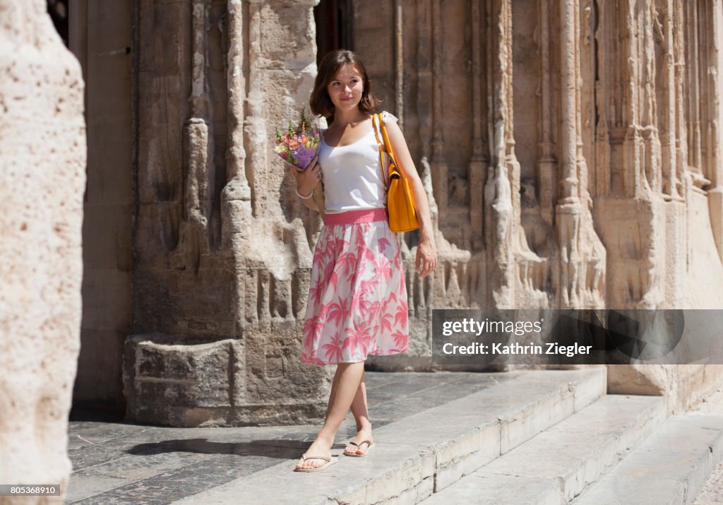 Young woman in front of Spanish Gothic building "La Lonja" in Palma de Mallorca