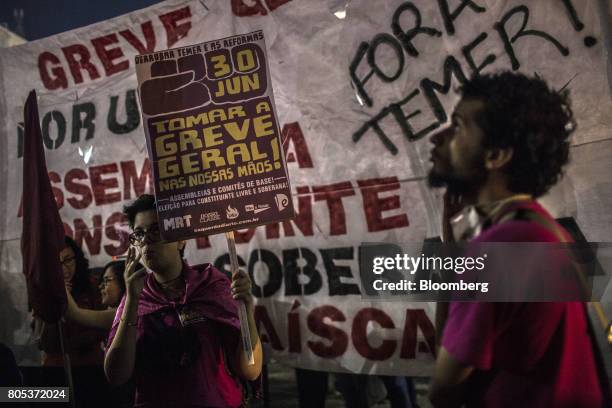 Demonstrators hold signs and a large a banner during a general strike against labor and retirement reforms in Rio de Janeiro, Brazil, on Friday, June...