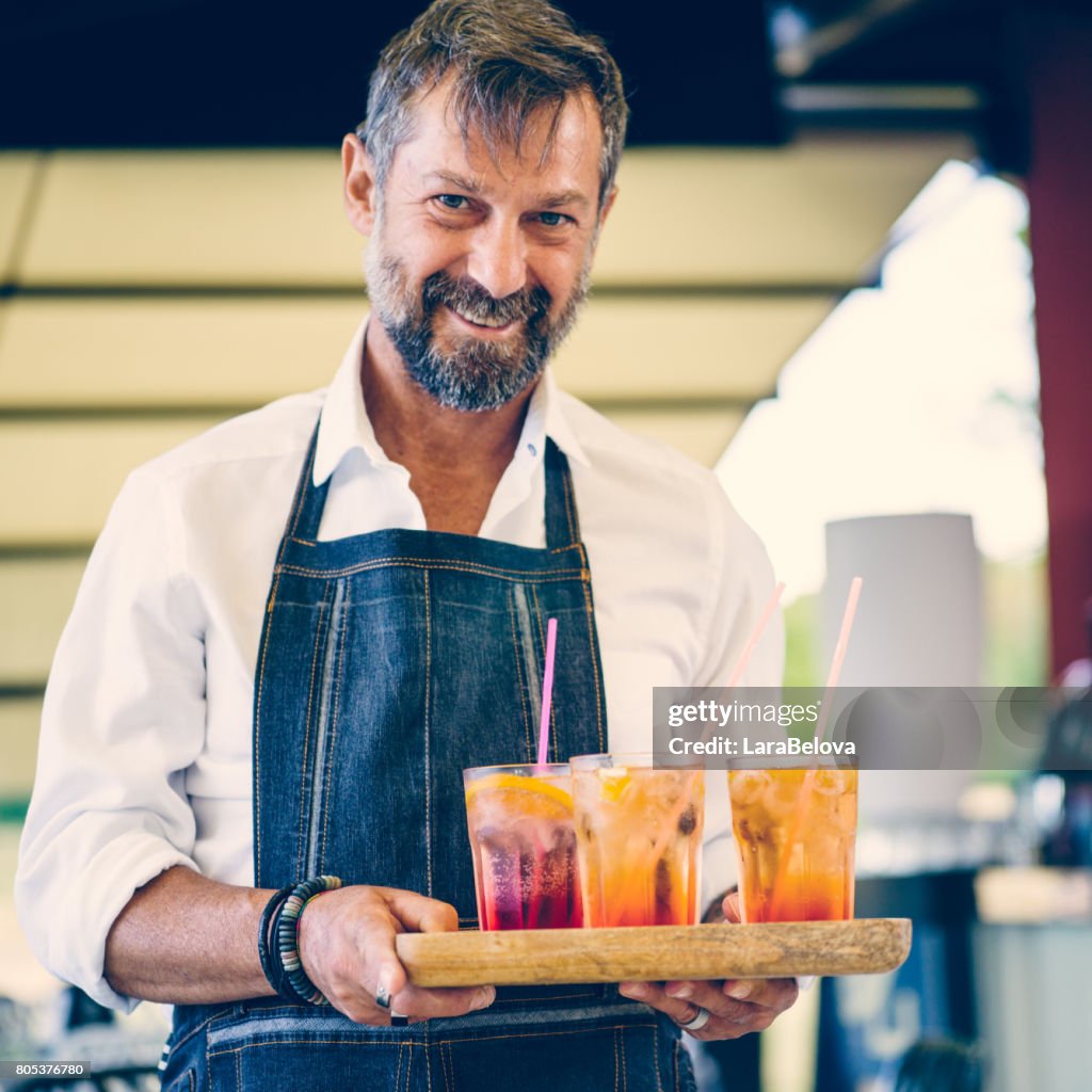 Reifer Mann Kellner im Straßencafé