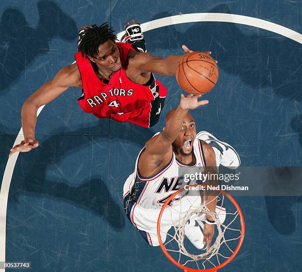 Chris Bosh of the Toronto Raptors rebounds against Trenton Hassell of the New Jersey Nets at the IZOD Center April 5, 2008 in East Rutherford, New...