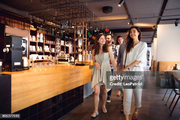 friends celebrating a party in a cafe - entering stock pictures, royalty-free photos & images