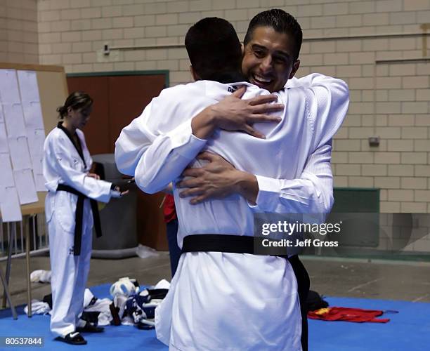 Jean Lopez hugs brother Mark Lopez as Diana Lopez makes a phone call in the background following the Taekwando Olympic Trials at the Veterans...