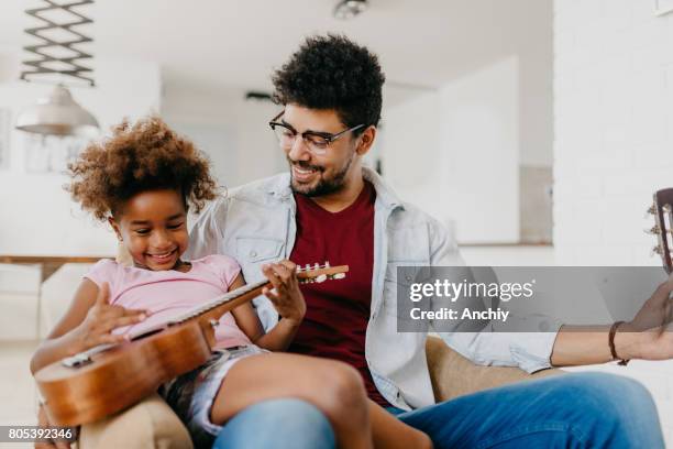 cute kid playing the ukulele for her dad. - cool guitar stock pictures, royalty-free photos & images