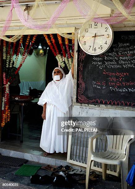 Sadhvi or Nun stands at the entrance of an upashray as she welcomes devotees coming to visit unseen 78-year-old woman Taraben Chovatia, undergoing...