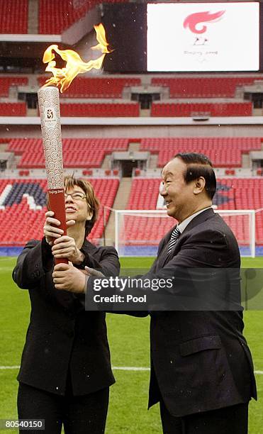 Executive Vice-President of the Beijing Organizing Committee, Jiang Xiaoyu hands the lit Olympic torch to Deputy Mayor of London, Nicky Gavron at...