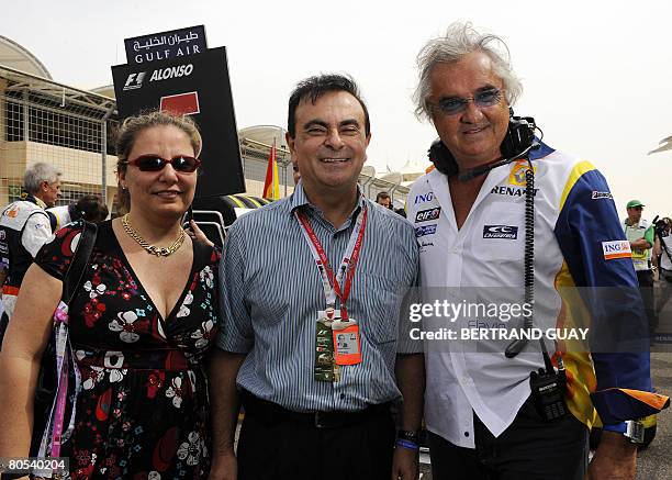 Carlos Ghosn , CEO of Renault and Nissan and his wife Rita pose with Renault's team chief Flafio Briatore in the starting grid of the Sakhir...