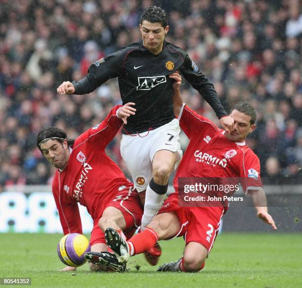 Cristiano Ronaldo of Manchester United clashes with Julio Arca and Luke Young of Middlesbrough during the Barclays FA Premier League match between...