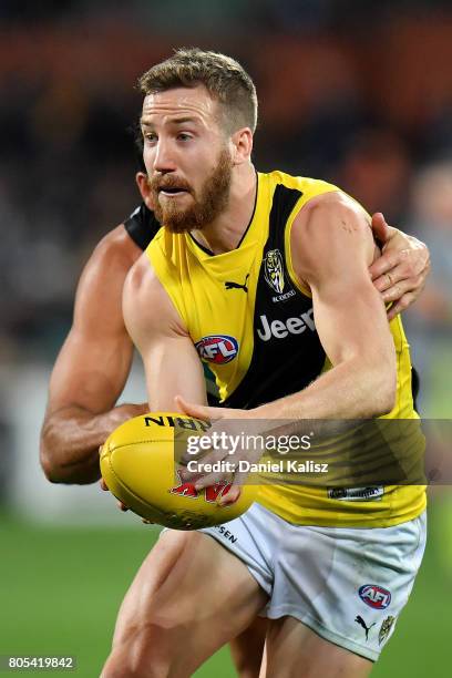 Kane Lambert of the Tiger looks to pass the ball during the round 15 AFL match between the Port Adelaide Power and the Richmond Tigers at Adelaide...