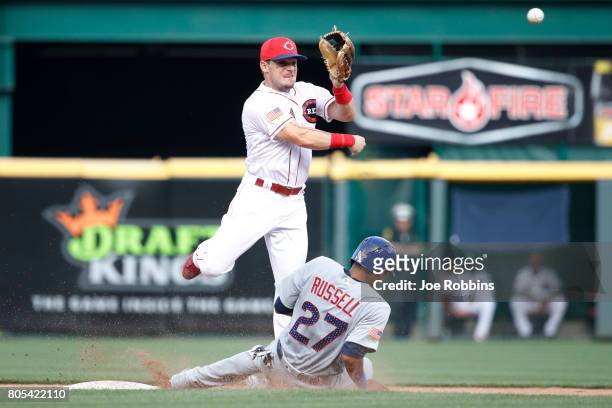 Scooter Gennett of the Cincinnati Reds turns a double play over the sliding Addison Russell of the Chicago Cubs in the sixth inning of a game at...