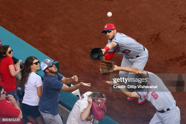 Anthony Rendon and Stephen Drew of the Washington Nationals attempt to catch a pop foul against the St. Louis Cardinals in the first inning at Busch...