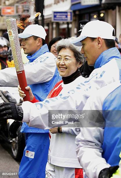 China's Ambassador to the United Kingdom Fu Ying carries the Olympic Torch during the Beijing Olympics torch relay on April 6, 2008 in London,...