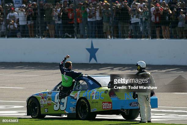 Carl Edwards, driver of the Aflac Ford, celebrates from his car after winning the NASCAR Sprint Cup Series Samsung 500 at Texas Motor Speedway on...