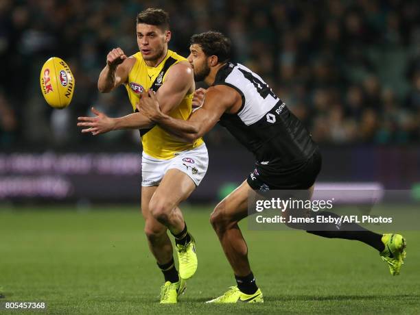 Dion Prestia of the Tigers is tackled by Paddy Ryder of the Power during the 2017 AFL round 15 match between the Port Adelaide Power and the Richmond...