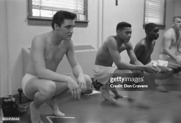 Along with fellow recruits, American musician Elvis Presley waits during physical examination upon their conscription into the US Army at the Fort...