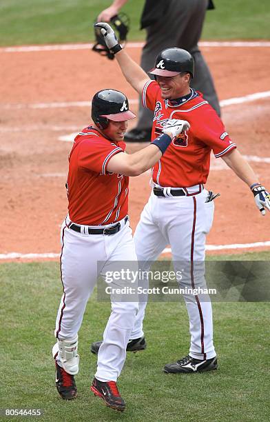 Mark Teixeira of the Atlanta Braves is congratulated by Chipper Jones after hitting a home run against the New York Mets at Turner Field on April 6,...