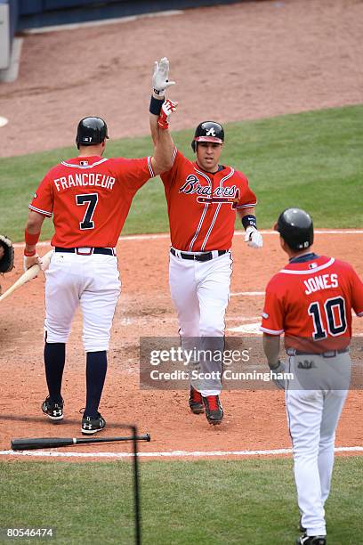 Mark Teixeira of the Atlanta Braves is congratulated by Jeff Francouer and Chipper Jones after hitting a home run against the New York Mets at Turner...