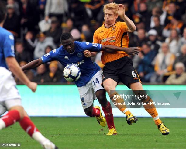 Portsmouth's Aruna Dindane and Hull City's Paul McShane battle for the ball during the Barclays Premier League match at the KC Stadium, Hull.
