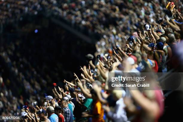 Fans look on as cars race during the Monster Energy NASCAR Cup Series 59th Annual Coke Zero 400 Powered By Coca-Cola at Daytona International...