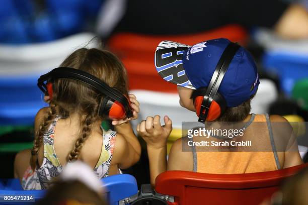 Fans look on as cars race during the Monster Energy NASCAR Cup Series 59th Annual Coke Zero 400 Powered By Coca-Cola at Daytona International...