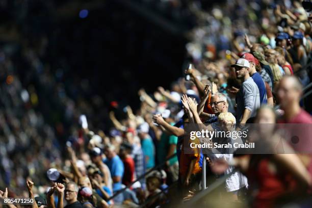 Fans look on as cars race during the Monster Energy NASCAR Cup Series 59th Annual Coke Zero 400 Powered By Coca-Cola at Daytona International...