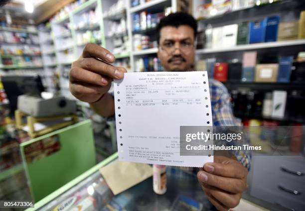 Shopkeeper showing new updated GST bill outside the store at Connaught place on July 1, 2017 in New Delhi, India.