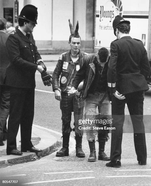 Policemen stop a couple of young punks in the street during the 'Stop the City' anarchist demonstration in London, September 1984.