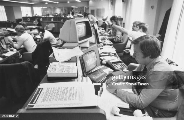 Staff at work at computer screens in a modern office in the City of London, circa 1990.