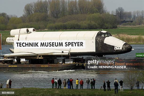 Spectators watch at the Russian spaceship "Buran 002 " being transported over the Rhine river in Rheinberg, western Germany. The shuttle with a...