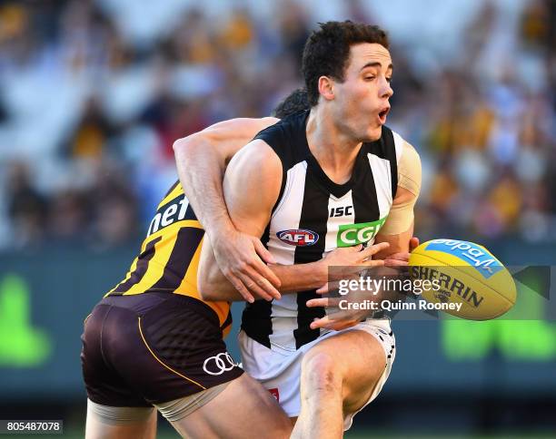 Jackson Ramsay of the Magpies is tackled by Ricky Henderson of the Hawks during the round 15 AFL match between the Hawthorn Hawks and the Collingwood...