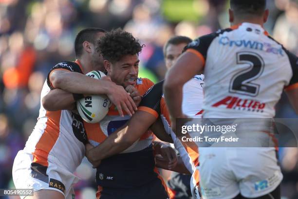 Dane Gagai of the Knights is tackled by the Tigers defence during the round 17 NRL match between the Newcastle Knights and the Wests TIgers at...