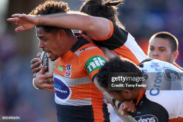 Dane Gagai of the Knights is tackled by the Tigers defence during the round 17 NRL match between the Newcastle Knights and the Wests TIgers at...