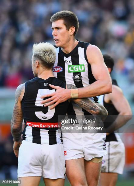 Mason Cox of the Magpies is congratulated by Jamie Elliott after kicking a goal during the round 15 AFL match between the Hawthorn Hawks and the...