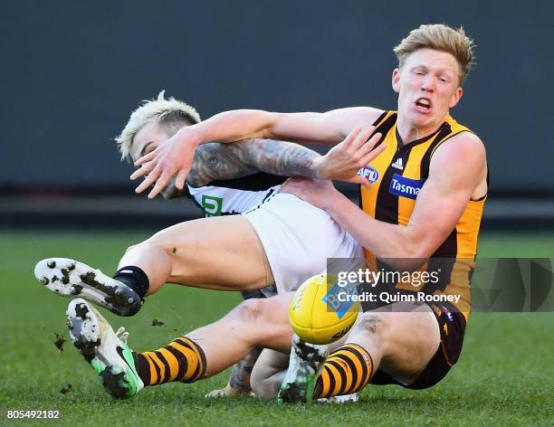 Jamie Elliott of the Magpies and James Sicily of the Hawks compete for the ball during the round 15 AFL match between the Hawthorn Hawks and the...