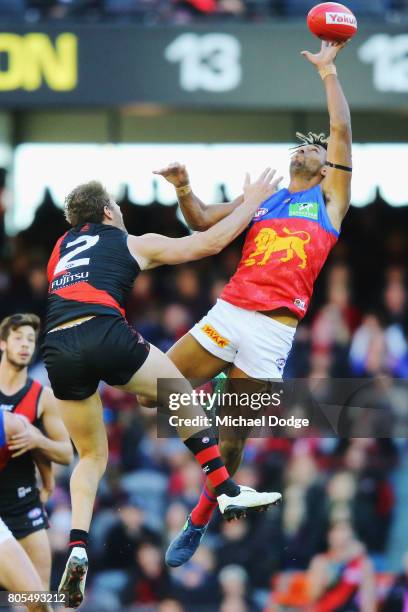 Archie Smith of the Lions wins the tap in the ruck from Tom Bellchambers of the Bombers during the round 15 AFL match between the Essendon Bombers...