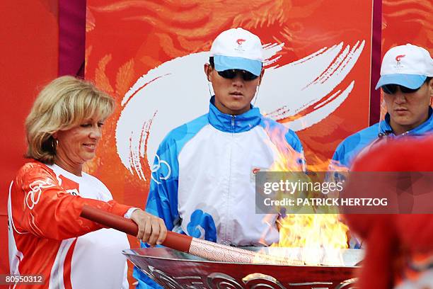 Former French swimming champion Christine Caron lights the altar at the end of the Beijing olympic torch relay at the Charlety stadium in Paris on...