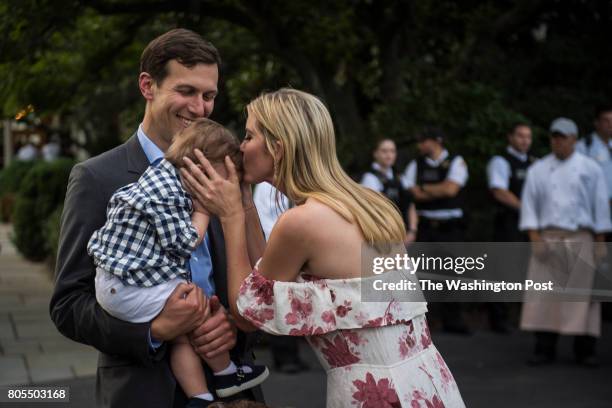 White House senior adviser Jared Kushner holds their son Theodore James Kushner as Ivanka Trump kisses him during the Congressional Picnic on the...