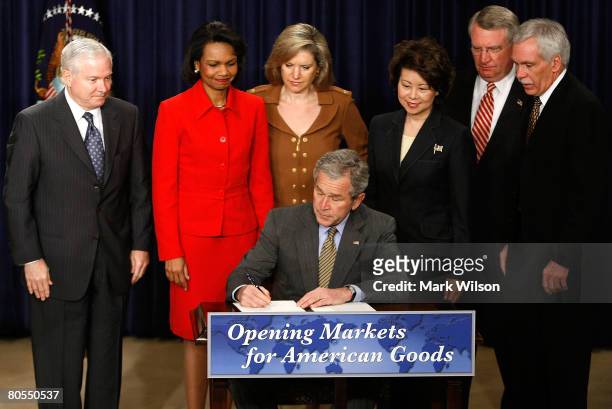 President George W. Bush signs a letter for Congress while flanked by, , Defense Secretary Robert Gates, Secretary of State Condoleezza Rice, U.S....