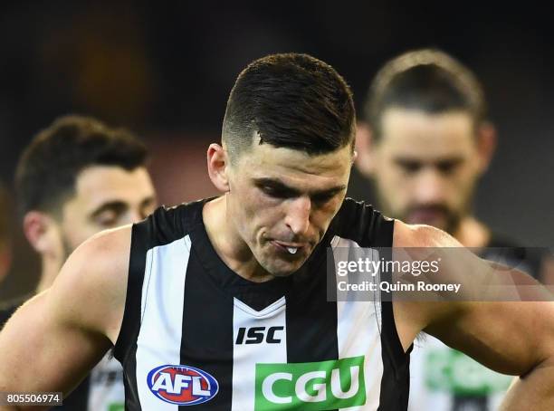 Scott Pendlebury of the Magpies and his team mates look dejected after losing the round 15 AFL match between the Hawthorn Hawks and the Collingwood...