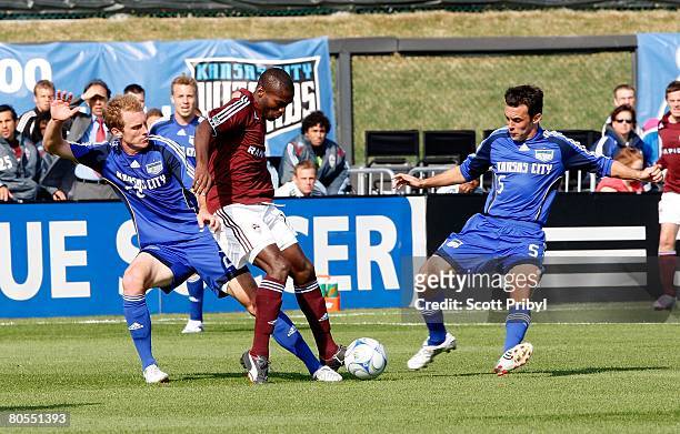 Omar Cummings of the Colorado Rapids tries to pass the ball against Kerry Zavagnin and Tyson Wahl of the Kansas City Wizards during the game at...
