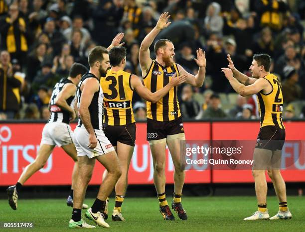 Jarryd Roughead of the Hawks is congratulated by team mates after kicking a goal during the round 15 AFL match between the Hawthorn Hawks and the...