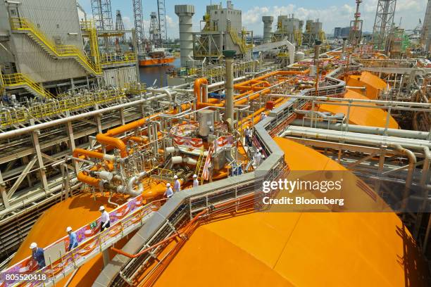 Attendees and crew members walk onboard the Hilli Episeyo floating liquefaction vessel , built for Golar Hilli Corp., a unit of Golar LNG Ltd., by...